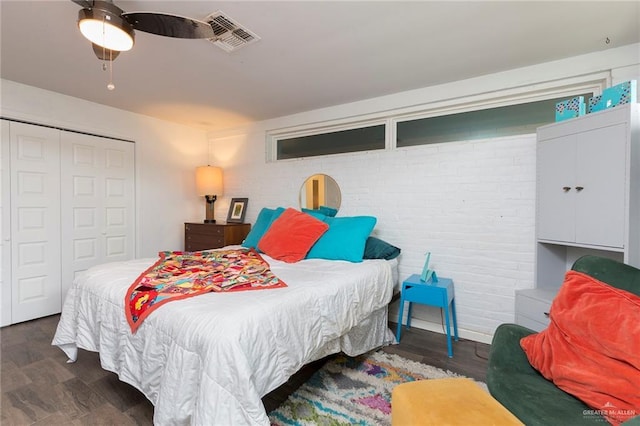 bedroom featuring a ceiling fan, visible vents, a closet, and wood finished floors