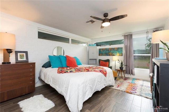 bedroom with a ceiling fan, visible vents, and wood finished floors