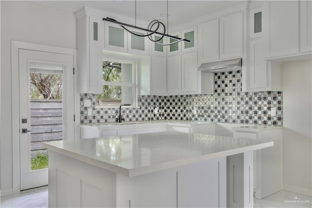 kitchen featuring premium range hood, white cabinetry, a kitchen island, and pendant lighting