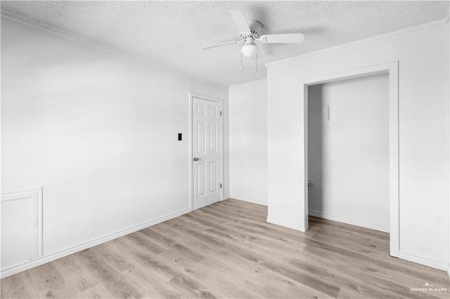unfurnished bedroom with baseboards, ornamental molding, a textured ceiling, ceiling fan, and wood finished floors