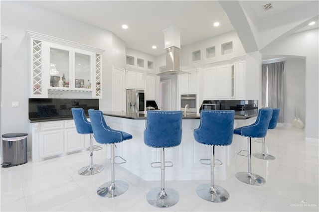 2511 Wisteria St, Rio Grande City, TX 78582 - kitchen with stainless steel appliances, dark countertops, a kitchen bar, glass insert cabinets, and recessed lighting