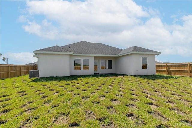 back of property featuring a yard and central AC