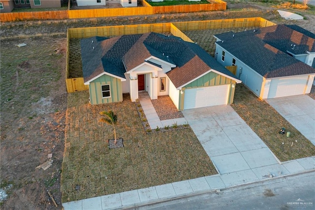 view of front of house featuring a garage, driveway, board and batten siding, and roof with shingles