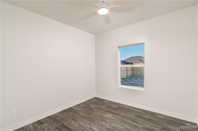 unfurnished room with dark wood-type flooring, baseboards, and a ceiling fan