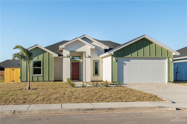 view of front of home with driveway, board and batten siding, an attached garage, and roof with shingles