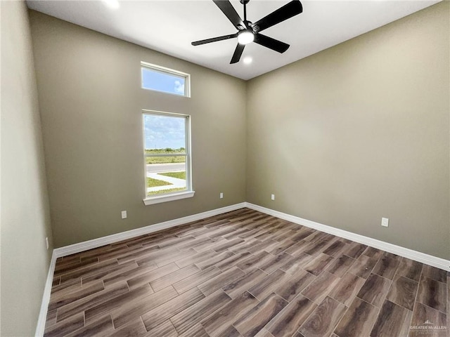 empty room featuring ceiling fan, a healthy amount of sunlight, and wood-type flooring