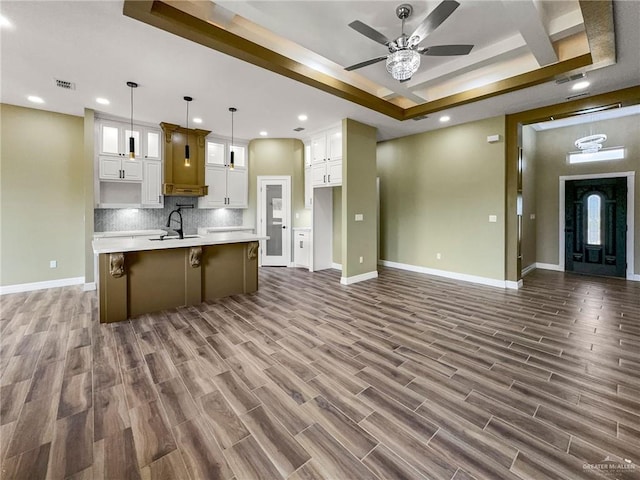 kitchen featuring backsplash, decorative light fixtures, white cabinets, dark hardwood / wood-style floors, and a large island