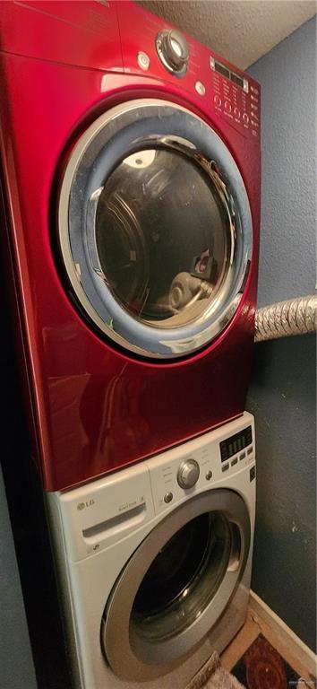 6201 Padre Blvd Unit 308, South Padre Island, TX 78597 - laundry area featuring stacked washer / drying machine and a textured ceiling