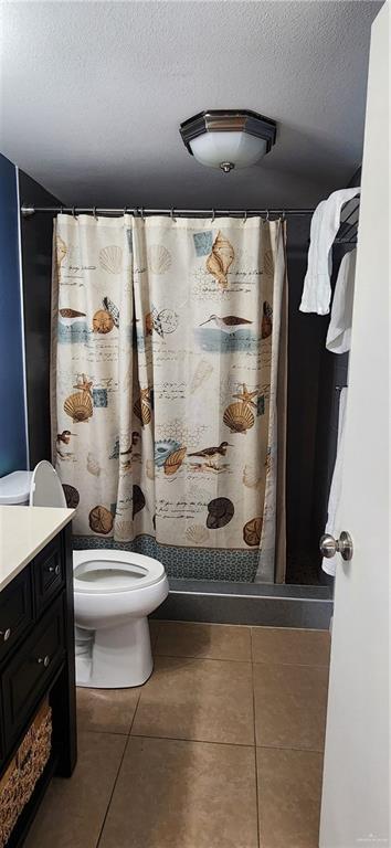 6201 Padre Blvd Unit 308, South Padre Island, TX 78597 - bathroom featuring vanity, a textured ceiling, tile patterned flooring, and a shower with curtain