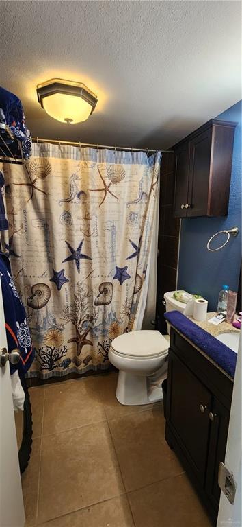 6201 Padre Blvd Unit 308, South Padre Island, TX 78597 - full bathroom featuring vanity, tile patterned floors, a textured ceiling, and a shower with curtain