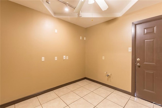 tiled empty room featuring track lighting and ceiling fan