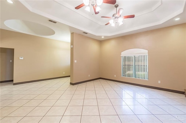 empty room featuring visible vents, baseboards, light tile patterned floors, a raised ceiling, and a ceiling fan