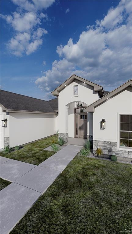 doorway to property featuring stone siding, a lawn, and stucco siding