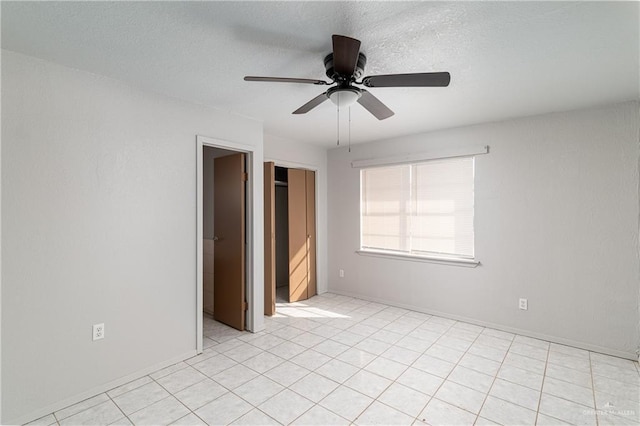 spare room featuring ceiling fan, baseboards, and a textured ceiling