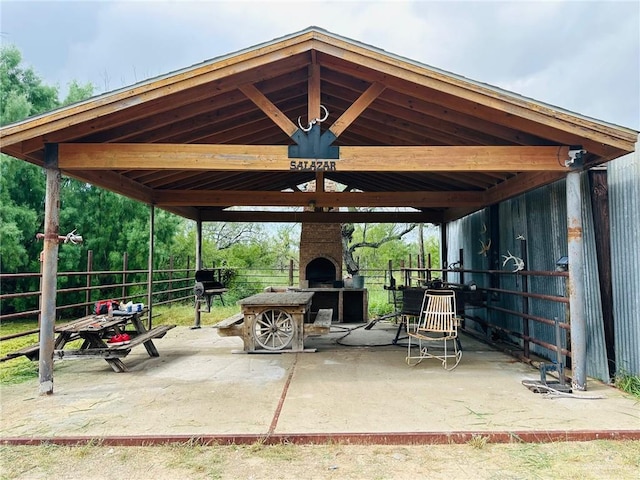 view of patio / terrace with a gazebo and an outdoor brick fireplace