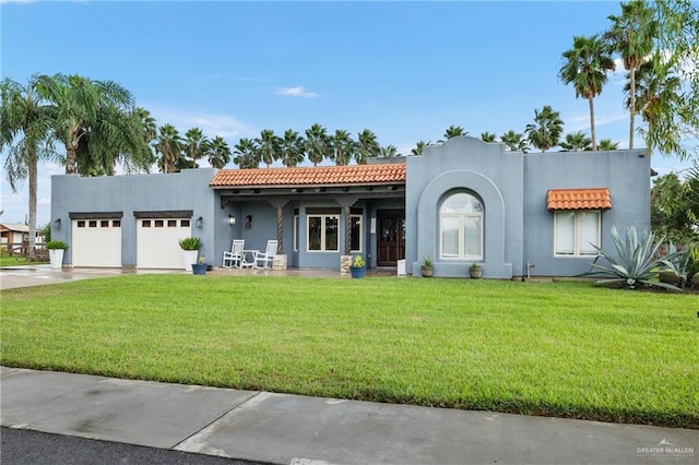 mediterranean / spanish house with a garage and a front lawn