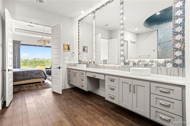 bathroom featuring hardwood / wood-style flooring, vanity, and backsplash