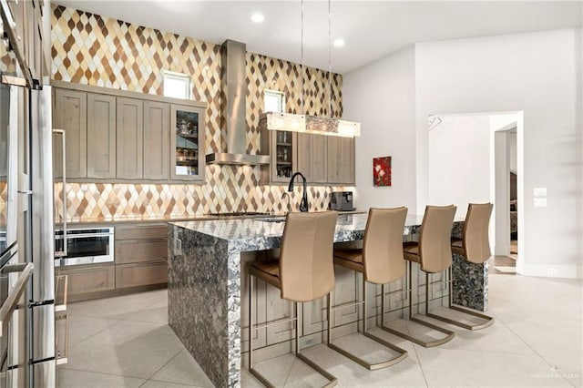 kitchen featuring a center island, a kitchen breakfast bar, wall chimney exhaust hood, tasteful backsplash, and stainless steel appliances