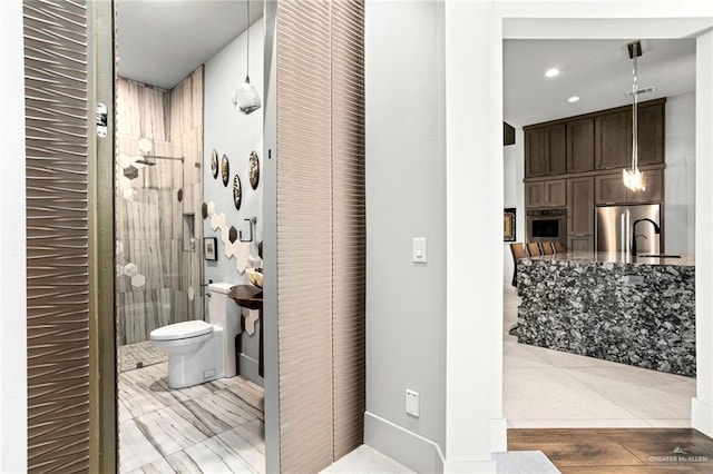 bathroom featuring wood-type flooring, toilet, and sink