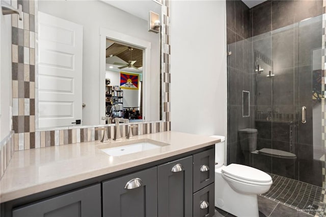 bathroom featuring ceiling fan, tile patterned floors, toilet, a shower with door, and vanity