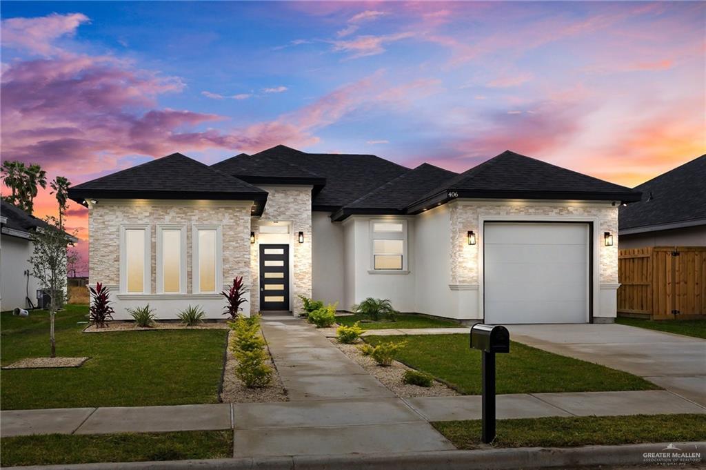 view of front of property featuring a yard and a garage