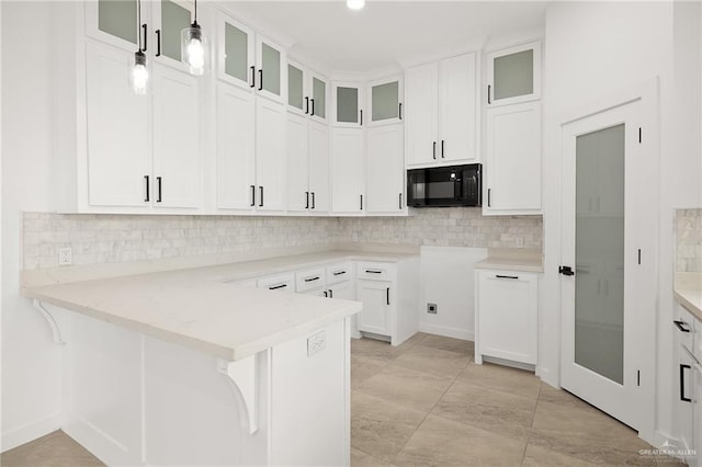 kitchen with white cabinets, backsplash, decorative light fixtures, and kitchen peninsula