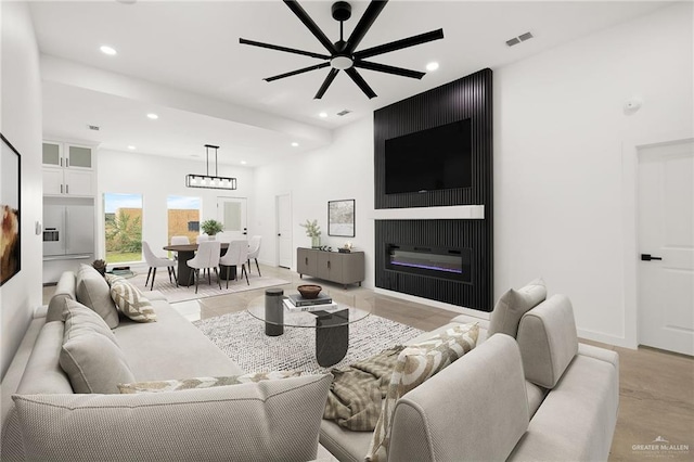 living room featuring ceiling fan and a fireplace