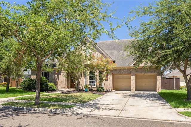 obstructed view of property with a garage and a front lawn