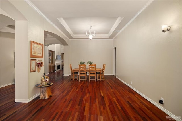 unfurnished dining area featuring an inviting chandelier, dark hardwood / wood-style floors, a raised ceiling, and crown molding