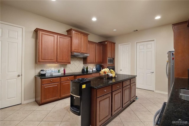 kitchen with decorative backsplash, dark stone countertops, light tile patterned floors, and stainless steel appliances