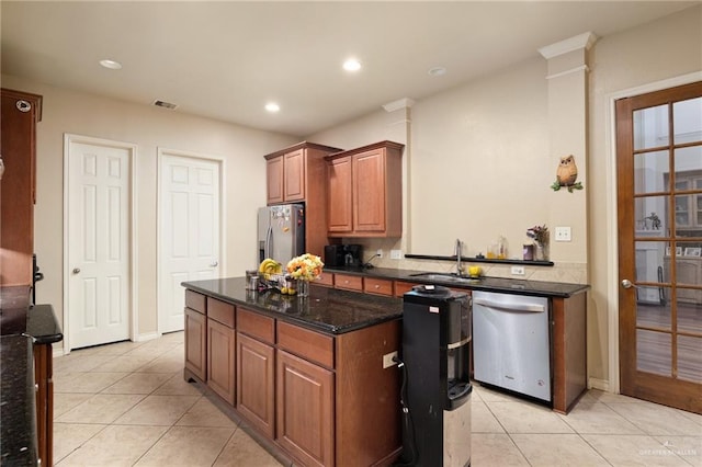 kitchen featuring dark stone counters, sink, light tile patterned floors, and stainless steel appliances