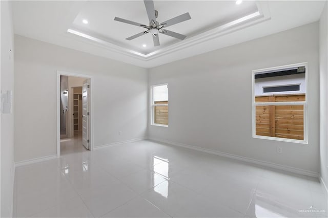 unfurnished bedroom with recessed lighting, a raised ceiling, baseboards, and light tile patterned flooring