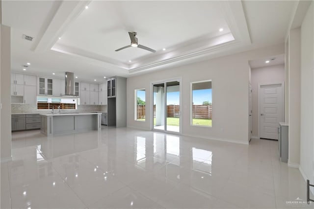 unfurnished living room featuring a ceiling fan, visible vents, a raised ceiling, recessed lighting, and light tile patterned flooring