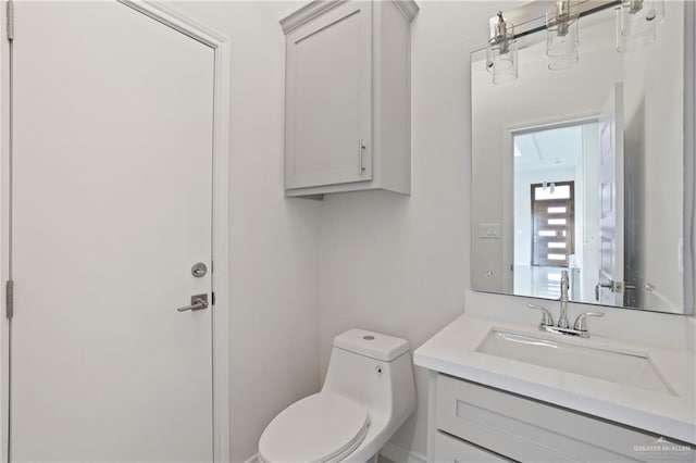 half bath featuring vanity and toilet