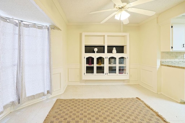 3208 Kiwi Ave, Mcallen, TX 78504 - unfurnished dining area featuring a decorative wall, wainscoting, ceiling fan, a textured ceiling, and light tile patterned flooring