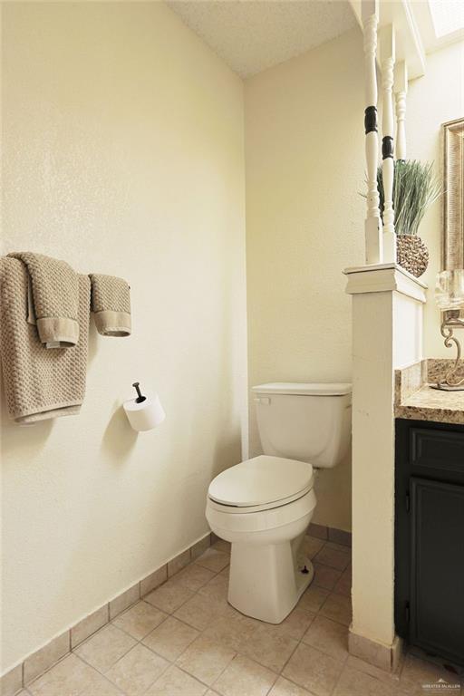 3208 Kiwi Ave, Mcallen, TX 78504 - bathroom with toilet, vanity, baseboards, and tile patterned floors