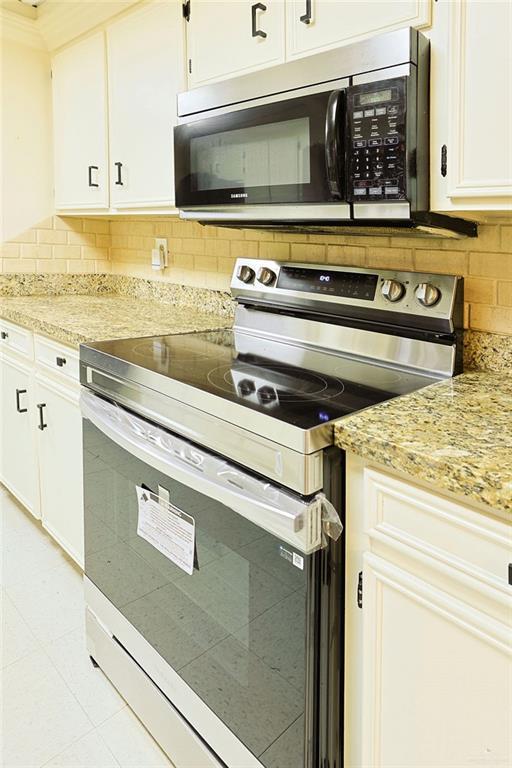 3208 Kiwi Ave, Mcallen, TX 78504 - kitchen featuring stainless steel electric range, tasteful backsplash, white cabinets, and light stone counters