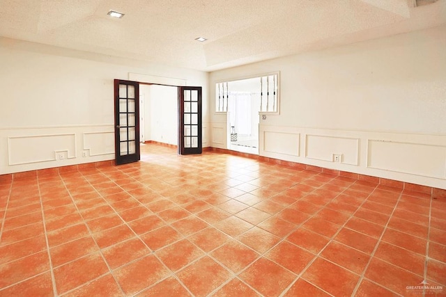 3208 Kiwi Ave, Mcallen, TX 78504 - tiled spare room with a decorative wall, french doors, a wainscoted wall, and a textured ceiling