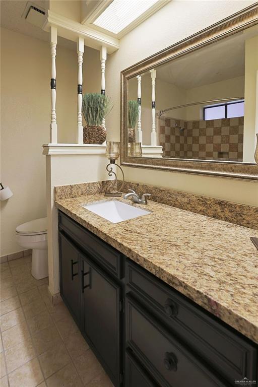 3208 Kiwi Ave, Mcallen, TX 78504 - bathroom with vanity, toilet, tiled shower, and tile patterned flooring