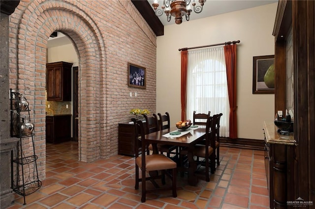 dining room with tile patterned flooring and brick wall