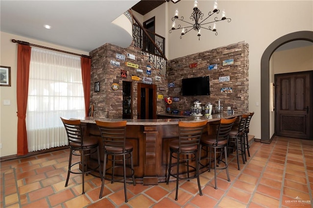 bar featuring tile patterned floors and a notable chandelier