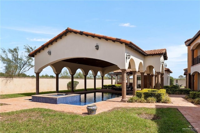 view of pool with a lawn and an in ground hot tub