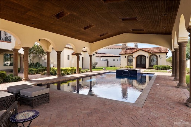 view of pool featuring an in ground hot tub and a patio