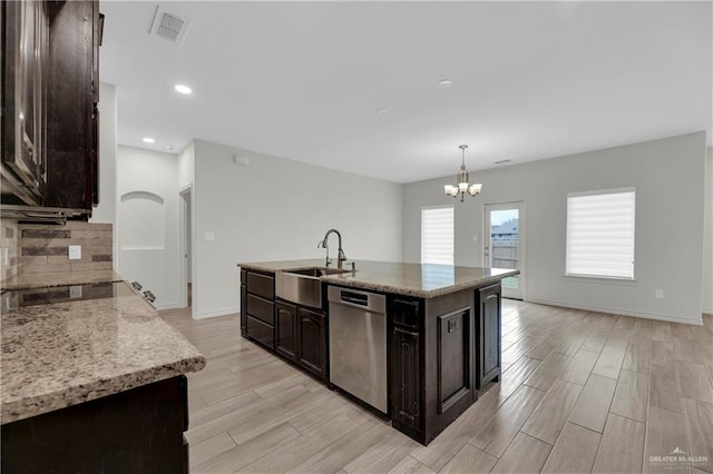 kitchen with sink, stainless steel dishwasher, a center island with sink, and light wood-type flooring