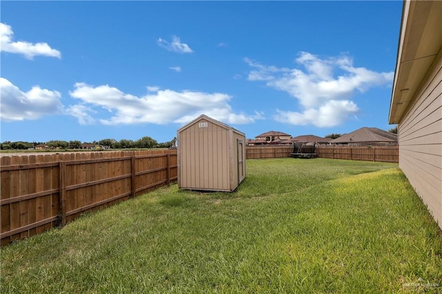 view of yard with a fenced backyard, an outdoor structure, and a storage shed