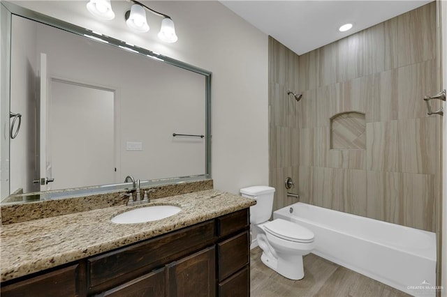 full bathroom featuring toilet, shower / washtub combination, wood finished floors, and vanity