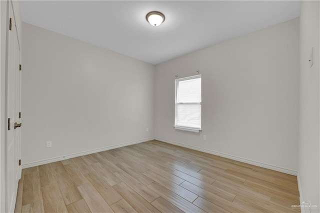 empty room with baseboards and light wood finished floors