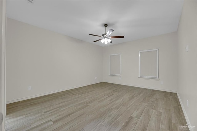 empty room with light wood-style floors, ceiling fan, and baseboards