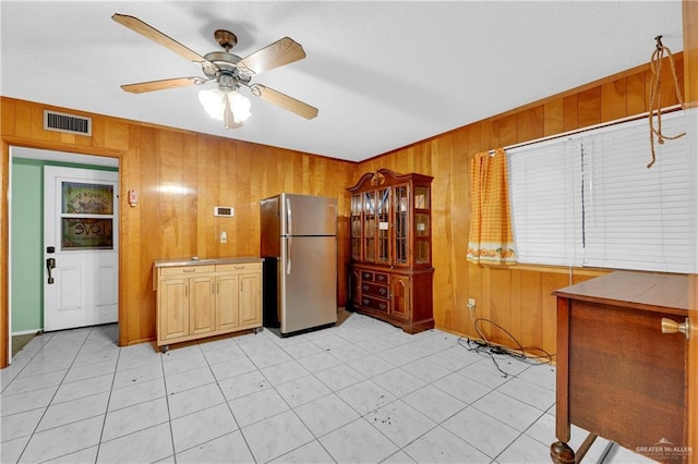 405 S 29th St, Mcallen, TX 78501 - kitchen with freestanding refrigerator, visible vents, ceiling fan, and wooden walls