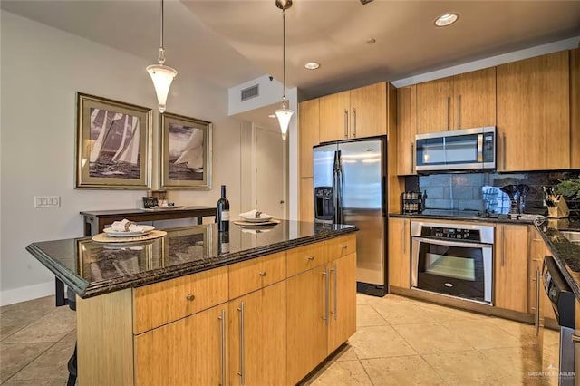 310 Padre Blvd, South Padre Island, TX 78597 - kitchen featuring appliances with stainless steel finishes, dark stone counters, decorative backsplash, an island with sink, and light tile patterned floors